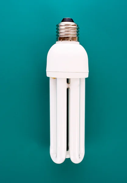 Энергосберегающая лампочка на голубом — стоковое фото