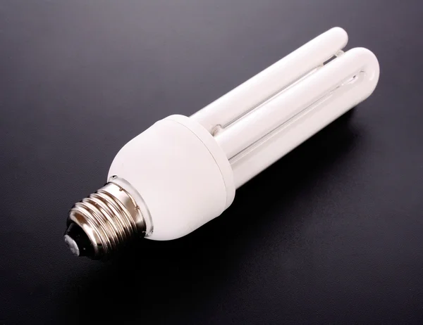 Energy saving light bulb on black — Stock Photo, Image