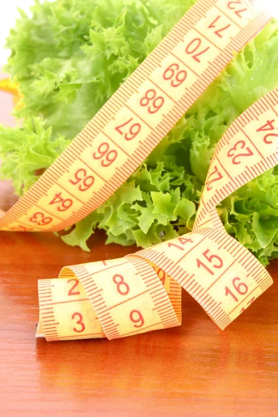 Groene salade en maatregel tape geïsoleerd op wit — Stockfoto