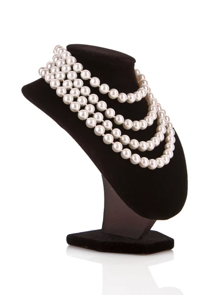 Collana di perle su supporto isolato su bianco — Foto Stock