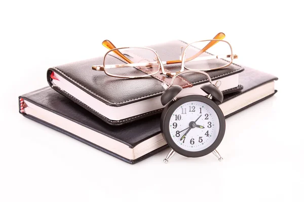 Notebook ve saatin üzerinde beyaz izole gözlük — Stok fotoğraf
