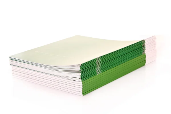 白で隔離される緑の雑誌の山 — ストック写真