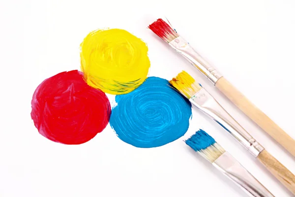 Três cores básicas de pintura e pincéis isolados sobre branco — Fotografia de Stock