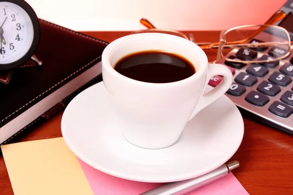 Xícara de café, livro, relógio e calculadora em mesa de madeira — Fotografia de Stock