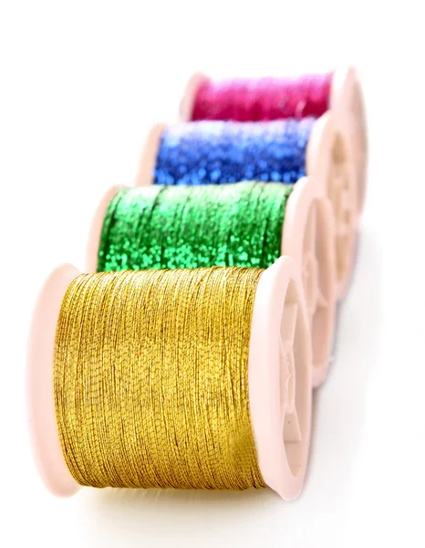 Mucchio di bobine colorate di filo di lurex isolato su bianco — Foto Stock
