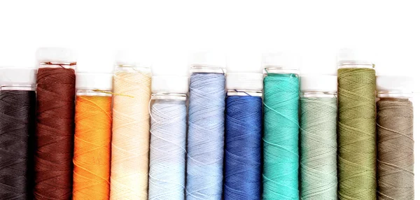 Pile of coloured bobbins of lurex thread isolated on white — Stock Photo, Image