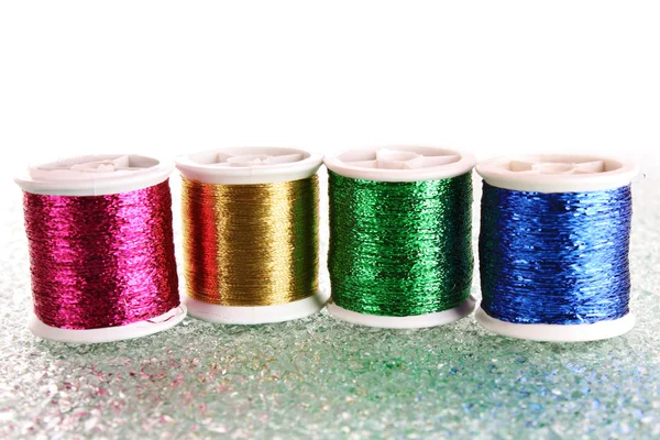 Gekleurde spoelkokers van threads, wollen ballen en kussen voor pinnen — Stockfoto