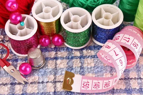 Coloured bobbins of threads, woolen balls and cushion for pins i — Stock Photo, Image