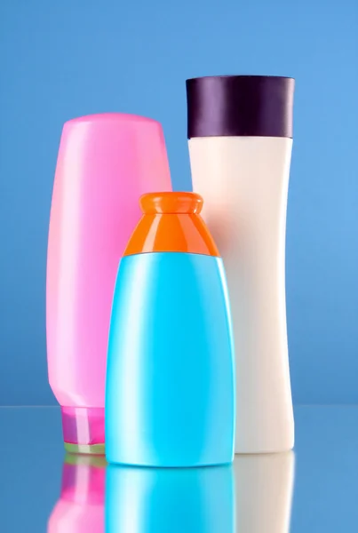 Botellas de productos de salud y belleza sobre fondo azul — Foto de Stock