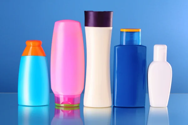 Bottiglie di prodotti di salute e bellezza su sfondo blu — Foto Stock