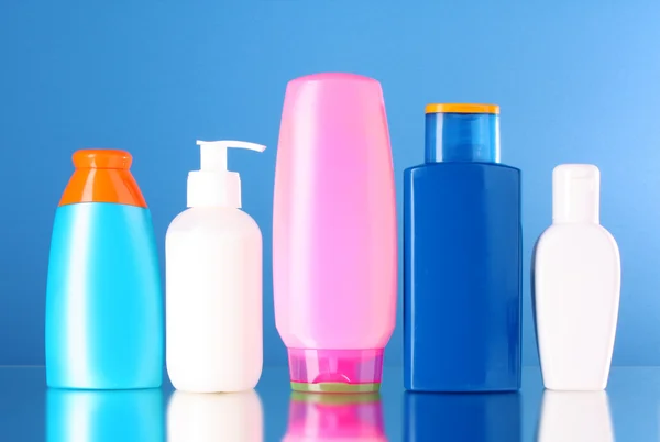 Bottles of health and beauty products on blue background — Stock Photo, Image