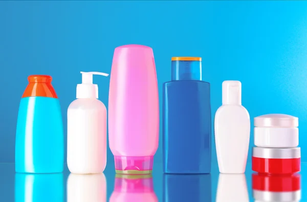 Bottles of health and beauty products on blue background — Stock Photo, Image