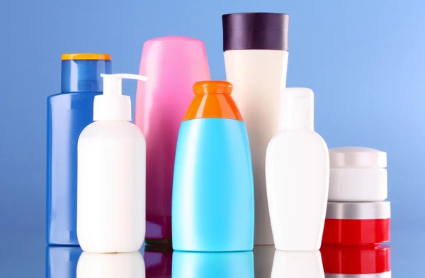 Botellas de productos de salud y belleza sobre fondo azul — Foto de Stock