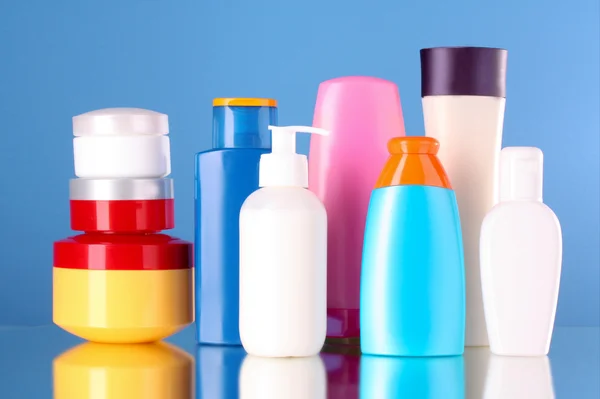 Lahve zdravotnických a kosmetických produktů na modrém pozadí — Stock fotografie