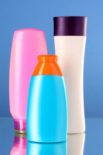 Garrafas de produtos de saúde e beleza em fundo azul — Fotografia de Stock