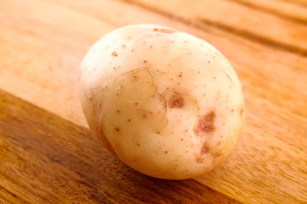Potato on wooden surface — Stock Photo, Image