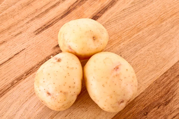 Potato on wooden surface — Stock Photo, Image