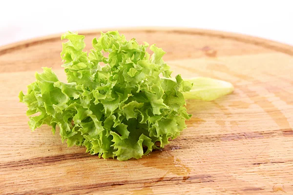 Foglie di insalata verde su superficie di legno — Foto Stock