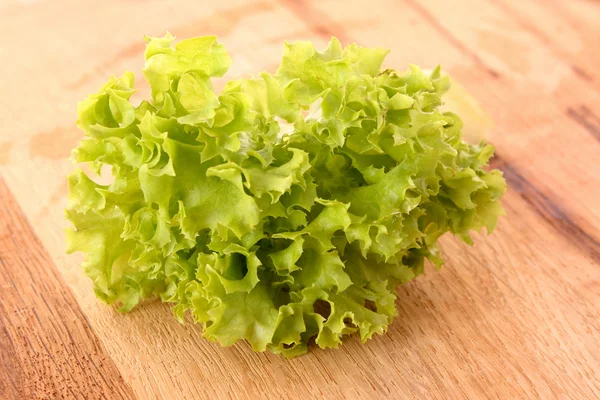Зеленый салат на деревянной поверхности — стоковое фото