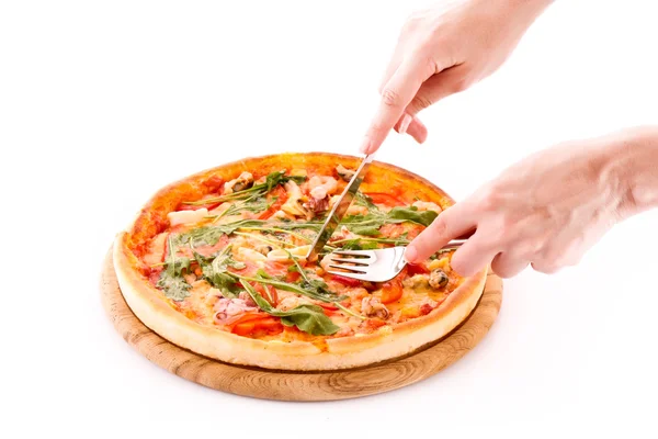 Кто-то режет пиццу, изолированную на белом — стоковое фото