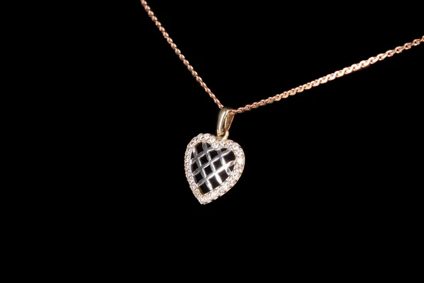 Pendentif précieux en forme de coeur sur une chaîne dorée sur fond noir — Photo