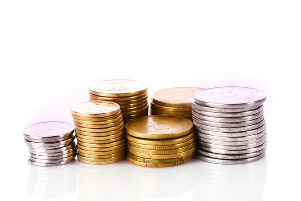 Många mynt i kolumnen isolerad på vit — Stockfoto