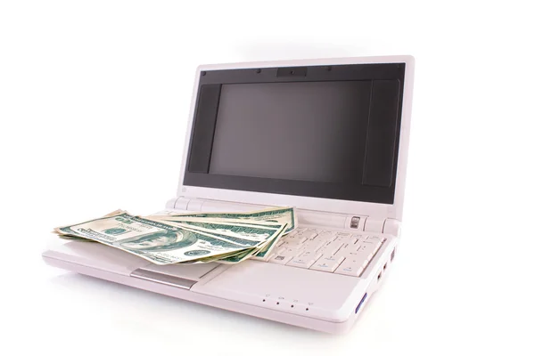 Kilka banknotów dolara na laptopa na białym tle — Zdjęcie stockowe