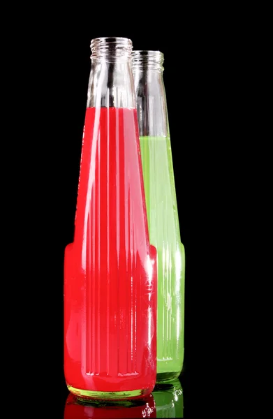 Cocktail vert et rouge dans une bouteille en verre sur fond noir — Photo