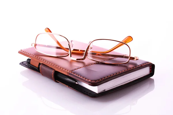 Brýle a notebook izolovaných na bílém — Stock fotografie