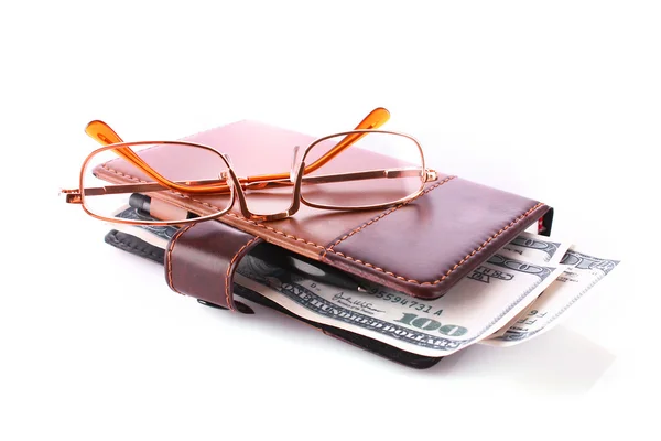 Okulary, notatnik i Dolar banknotów na białym tle — Zdjęcie stockowe