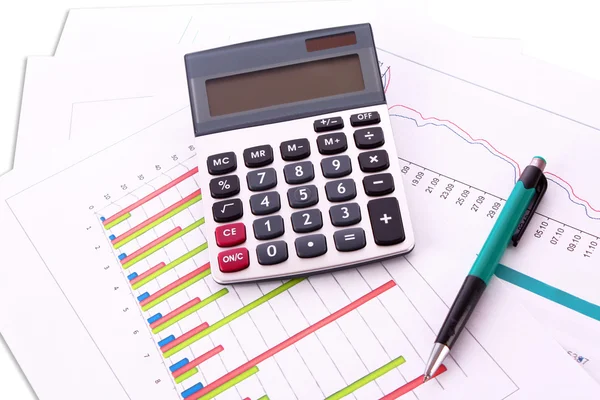Kalkulačka a pera na pozadí grafu — Stock fotografie