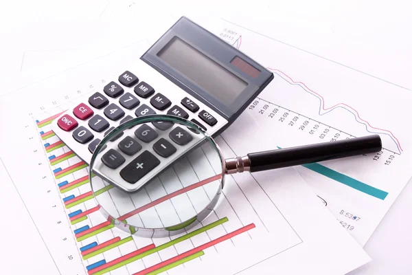 Kalkulačka a Lupa na pozadí grafu — Stock fotografie