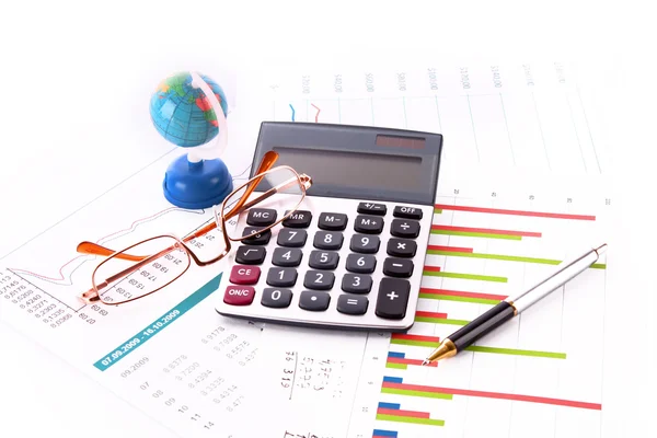Kalkulator, pióra, okulary, glob i niektóre wykresy — Zdjęcie stockowe