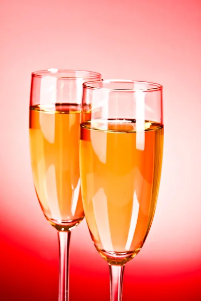 Glass with champagne on red — Stock Photo, Image