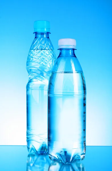 Wasserflaschen auf blauem Hintergrund — Stockfoto