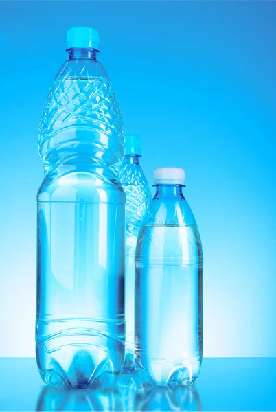 Butelki wody na niebieskim tle — Zdjęcie stockowe