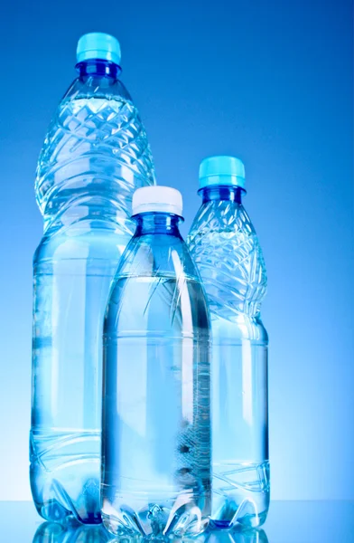 Бутылки воды на синем фоне — стоковое фото