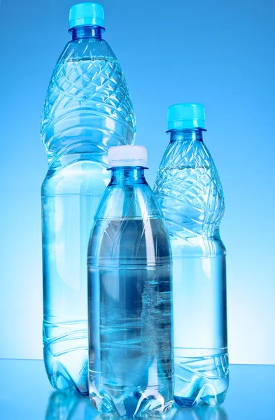 Wasserflaschen auf blauem Hintergrund — Stockfoto