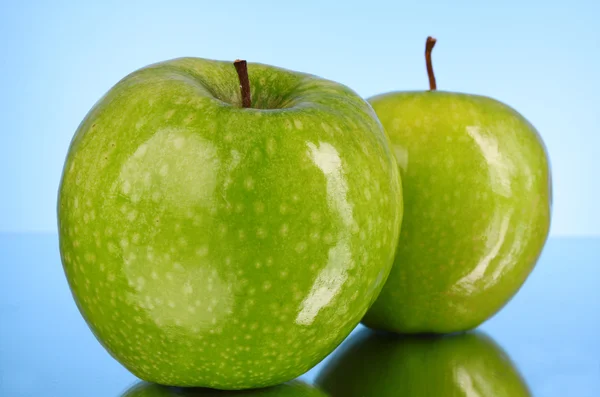 Two green apples on blue background — 스톡 사진