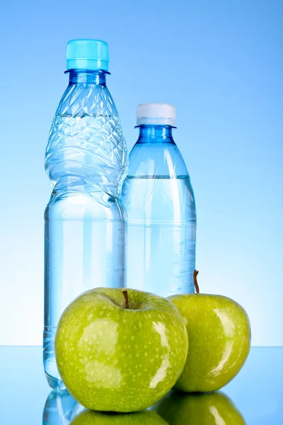 Mavi arka planda su şişeleri — Stok fotoğraf