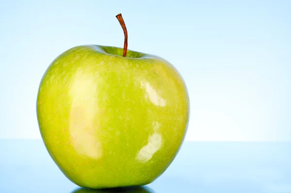Zielone jabłko na niebieskim tle — Zdjęcie stockowe
