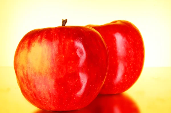 Két piros almák vörös háttérben — Stock Fotó