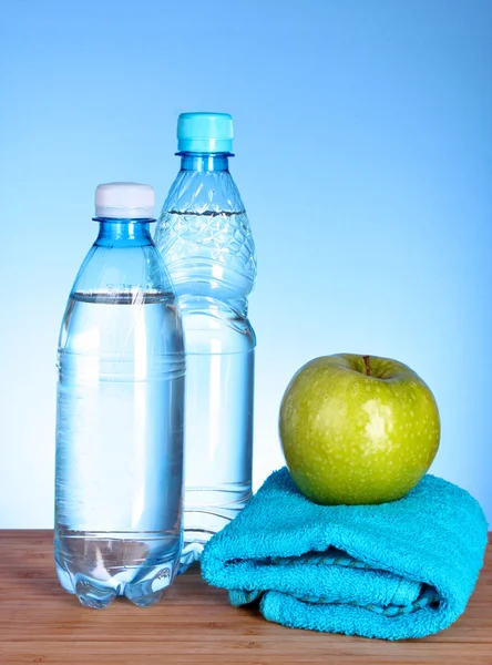Niebieska butelka wody, jabłko, sportowe ręcznik i centymetrem na bl — Zdjęcie stockowe
