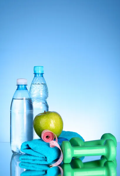 Bottiglia blu di acqua, mela, asciugamano sportivo, manubri e misura — Foto Stock
