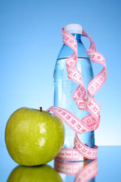 Taze kırmızı lezzetli elma, mavi backgr kasette ölçme ile şişe — Stok fotoğraf