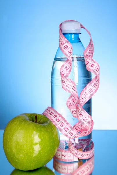 Taze kırmızı lezzetli elma, mavi backgr kasette ölçme ile şişe — Stok fotoğraf