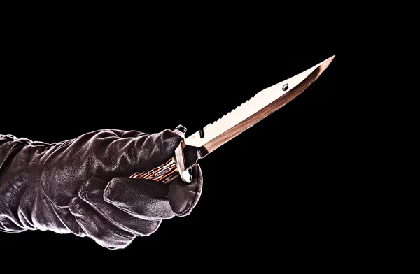 Нож в черной перчатке, изолированный на черном — стоковое фото