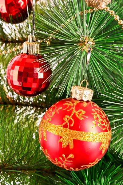 Κόκκινες μπάλες Χριστούγεννα μεταξύ Πρωτοχρονιά πράσινο δέντρο — Φωτογραφία Αρχείου
