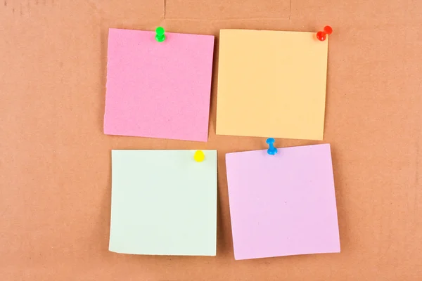 Four blank memo with colourful pins on cardboard — Stock Photo, Image