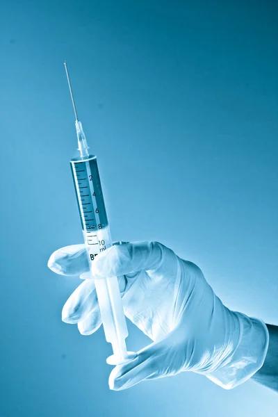Syringe in doctors hand in blue colors — Stock Photo, Image